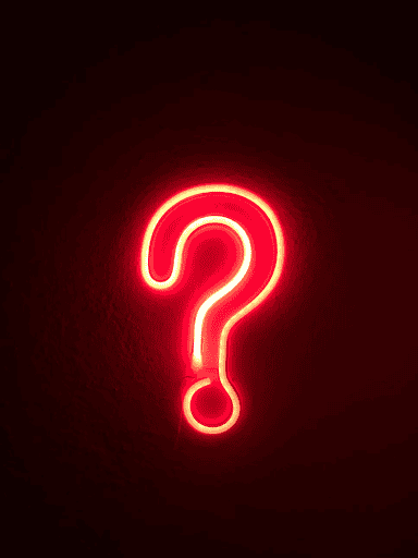 Glowing red neon question mark on a dark background