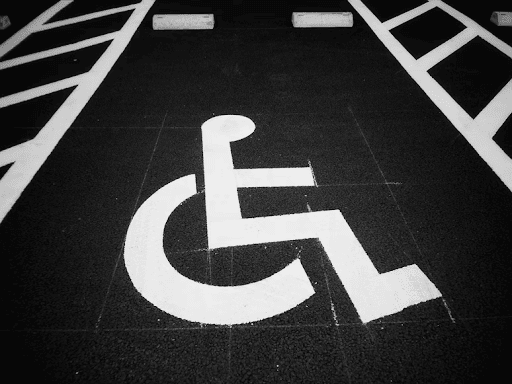 Handicap parking symbol painted on asphalt, representing accessibility