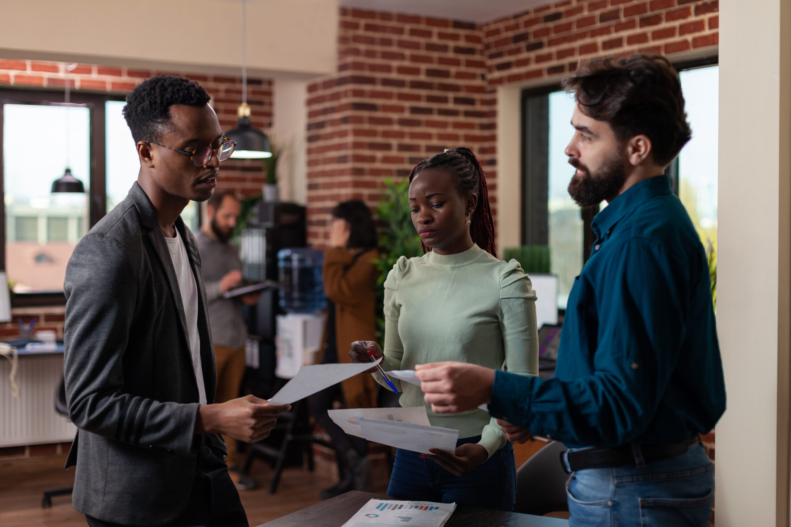 Group of professionals discussing documents in a modern office,